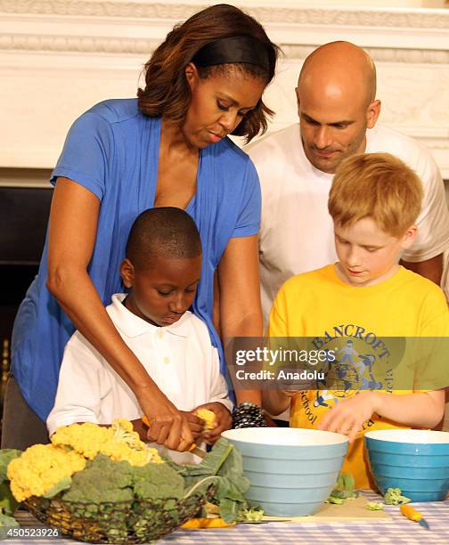 First lady Michelle Obama helps students from five District of Columbia schools to make food using the summer crop from the White House Kitchen...