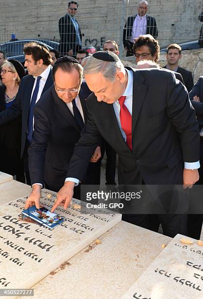 In this handout provided by the GPO, Israeli Prime Minister Benjamin Netanyahu and French President Francois Hollande lay tributes to the victims of...