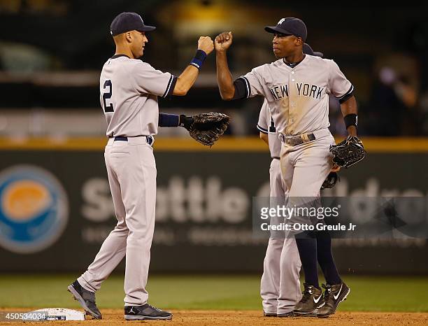Derek Jeter of the New York Yankees is congratulated by Alfonso Soriano after defeating the Seattle Mariners 6-3 at Safeco Field on June 12, 2014 in...