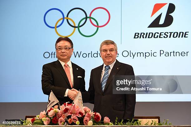 President of International Olympic Committee Thomas Bach and Bridgestone CEO Masaaki Tsuya shake hands during a news conference to announce the...