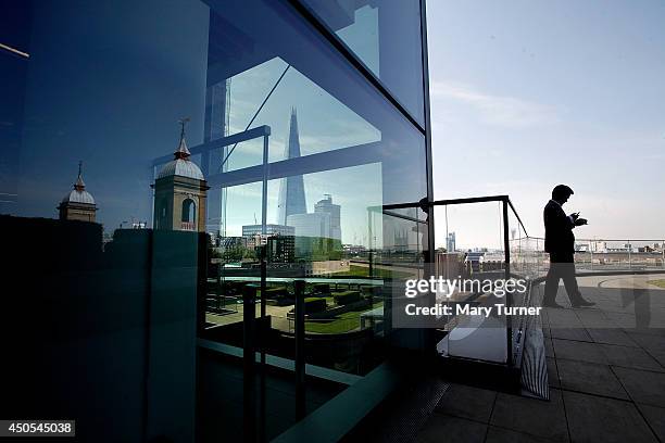 Businessman sends a text message from the Nomura rooftop gardens, which are opening to the public as part of Open Garden Squares Weekend 2014, on...