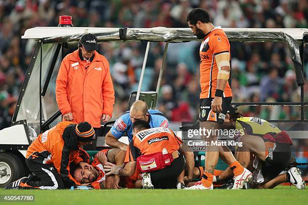 Dene Halatau of the Tigers is assisted on the field after sustaining an injury during the round 14 NRL match between the South Sydney Rabbitohs and...