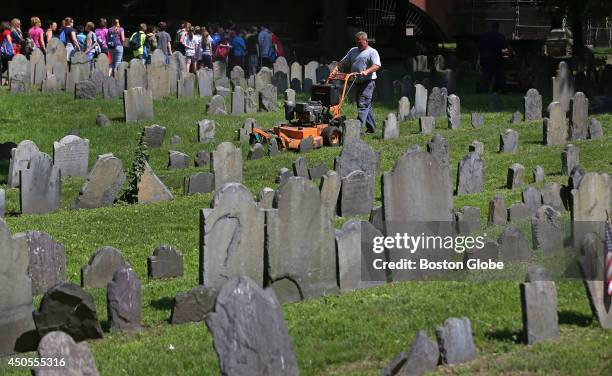 Kevin Boczowski with City of Boston Parks Cemetery Division mows the lawn at the Old Granary Burial Ground in Boston.