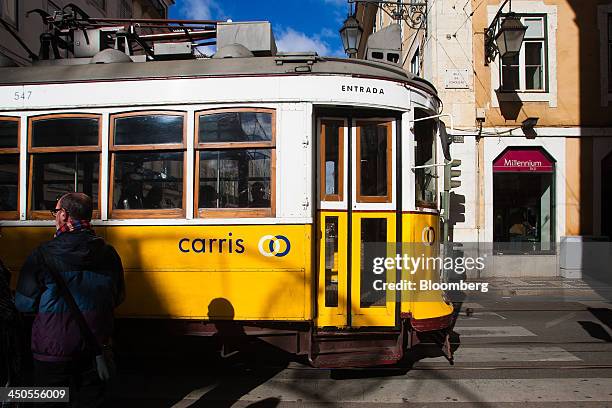 City tram operated by Carris Ferro de Lisboa passes a Millenium BCP Investimento bank branch, owned by Banco Comercial Portugues SA, in central...