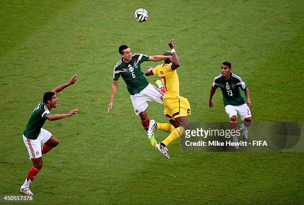 Hector Herrera of Mexico goes up for the ball with Stephane Mbia of Cameroon during the 2014 FIFA World Cup Brazil Group A match between Mexico and...