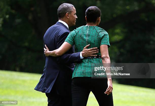 First lady Michelle Obama and U.S. President Barack Obama walk to a waiting Marine One helicopter after he made a statement on the situation in Iraq...