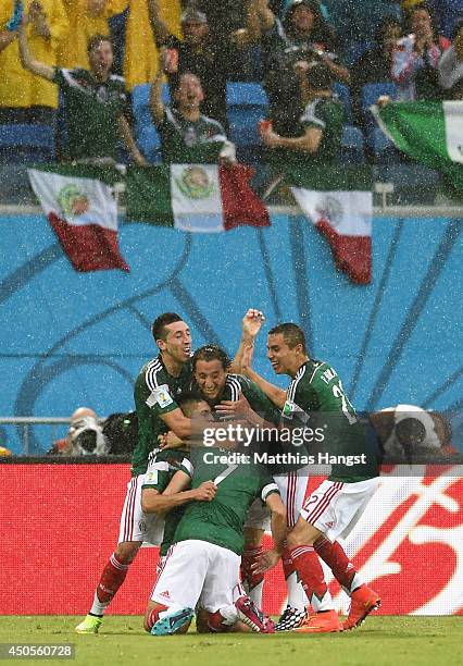 Oribe Peralta of Mexico celebrates his goal with teammates in the second half during the 2014 FIFA World Cup Brazil Group A match between Mexico and...