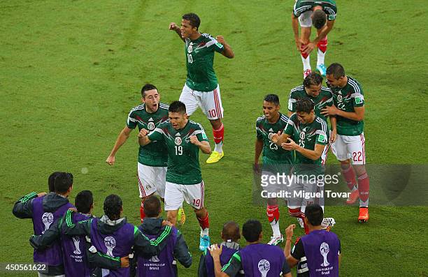 Oribe Peralta of Mexico runs to the sidelines to celebrate his goal with teammates during the 2014 FIFA World Cup Brazil Group A match between Mexico...