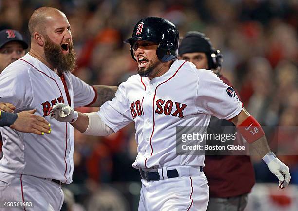 Shane Victorino, right, is welcomed back to the dugout by teammate Mike Napoli, left, following his seventh inning grand slam. The Boston Red Sox...