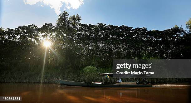 People boat along the Madre de Dios River in the Amazon lowlands on November 14, 2013 near Puerto Maldonado, Peru. The biologically diverse Madre de...