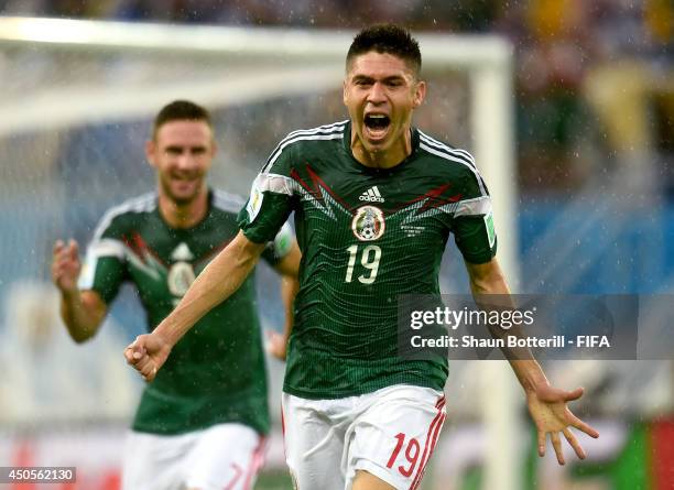 Oribe Peralta of Mexico celebrates after scoring a goal during the 2014 FIFA World Cup Brazil Group A match between Mexico and Cameroon at Estadio...