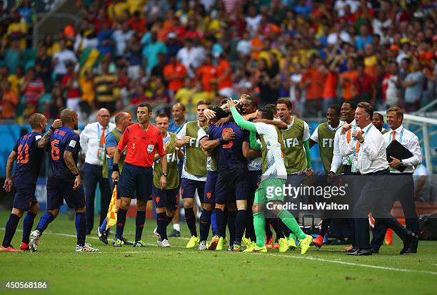 Robin van Persie of the Netherlands celebrates with teammates on the sideline after scoring his team's first goal during the 2014 FIFA World Cup...