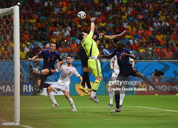 Iker Casillas of Spain and Robin van Persie of the Netherlands collide in the air as the ball carries to Stefan de Vrij of the Netherlands during the...