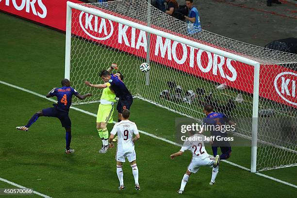 Iker Casillas of Spain and Robin van Persie of the Netherlands collide in the air as the ball carries to Stefan de Vrij of the Netherlands during the...