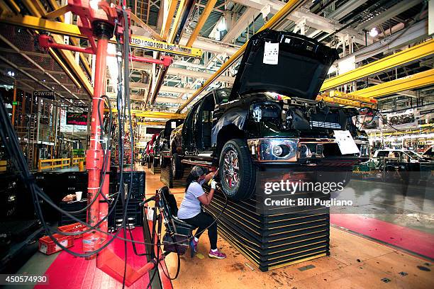 Ford worker Jacqueline Harris of Toledo, Ohio works on a new 2014 Ford F-150 truck while seated in a "happy seat" on the assembly line at the Ford...