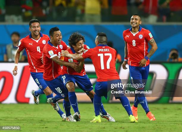 Jorge Valdivia of Chile is mobbed by his teammates after scoring the team's second goal during the 2014 FIFA World Cup Brazil Group B match between...