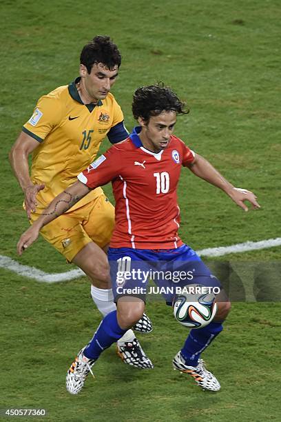 Chile's forward Jorge Valdivia holds off Australia's midfielder Mile Jedinak during a Group B football match between Chile and Australia at the...