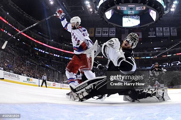 Benoit Pouliot of the New York Rangers runs into goaltender Jonathan Quick of the Los Angeles Kings and is called for goalie interference in the...