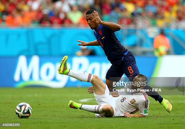 Andres Iniesta of Spain goes down next to Jonathan de Guzman of the Netherlands during the 2014 FIFA World Cup Brazil Group B match between Spain and...