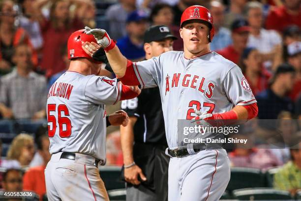 Mike Trout celebrates with Kole Calhoun of the Los Angeles Angels of Anaheim after scoring in the eighth inning against the Atlanta Braves at Turner...