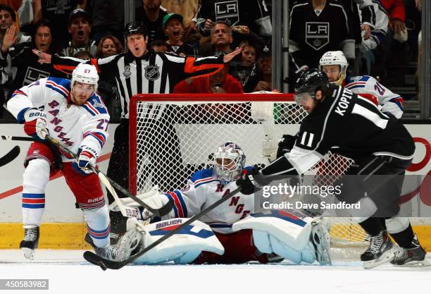 Goaltender Henrik Lundqvist of the New York Rangers watches as Anze Kopitar of the Los Angeles Kings reaches for the puck against Ryan McDonagh in...