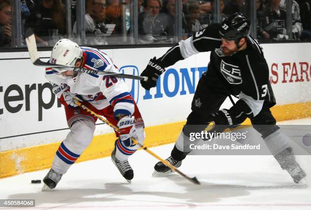 Willie Mitchell of the Los Angeles Kings tries to stop Martin St. Louis of the New York Rangers with his stick in the third period of Game Five of...
