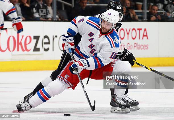 Derick Brassard of the New York Rangers tries to get control of the puck away from Dustin Brown of the Los Angeles Kings in the third period of Game...