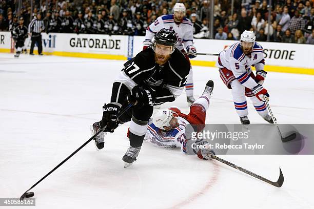 Jeff Carter of the Los Angeles Kings skates away with the puck as Ryan McDonagh of the New York Rangers falls to the ice during overtime of Game Five...