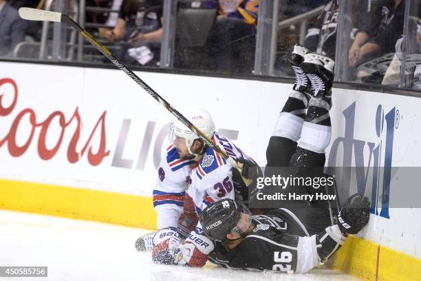 Slava Voynov of the Los Angeles Kings falls into the boards alongside Mats Zuccarello of the New York Rangers in overtime during Game Five of the...