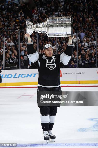 Dustin Brown of the Los Angeles Kings holds up the Stanley Cup Trophy following Game Five of the 2014 NHL Stanley Cup Final at Staples Center on June...