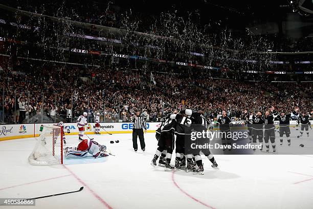 Alec Martinez and the Los Angeles Kings celebrate after scoring the game-winning double overtime goal on goaltender Henrik Lundqvist of the New York...