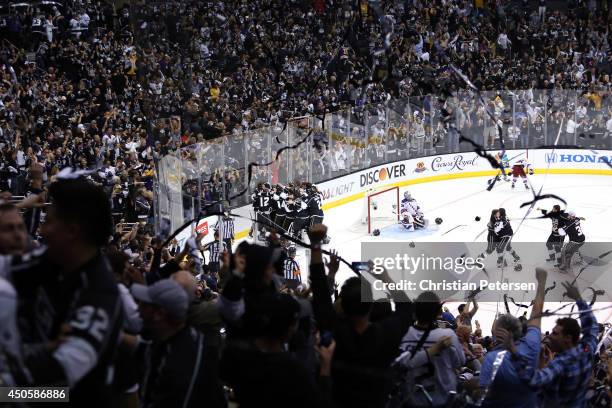 Alec Martinez of the Los Angeles Kings and the Kings celebrate after scoring the game-winning goal in double overtime against the New York Rangers to...