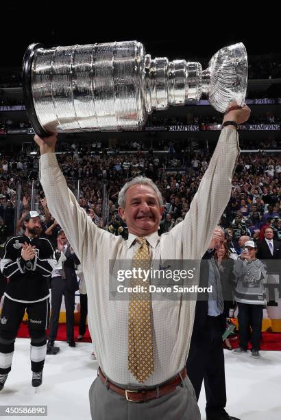 Head coach Darryl Sutter of the Los Angeles Kings lifts the Stanley Cup after his team won Game Five 3-2 in double overtime over the New York Rangers...