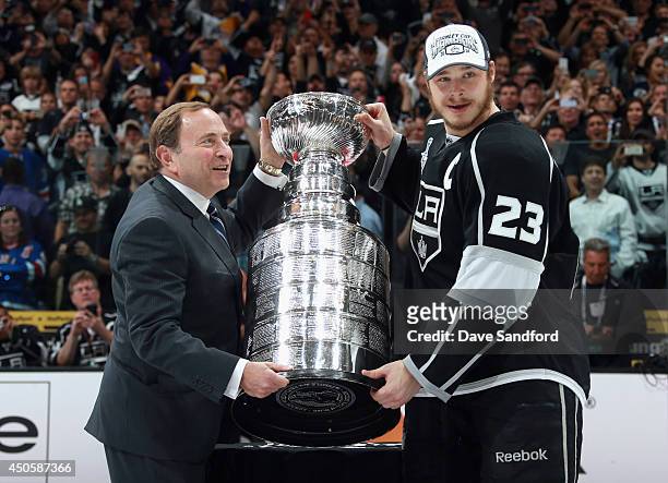 Dustin Brown of the Los Angeles Kings shakes hands with NHL Commissioner Gary Bettman after the Kings win the Stanley Cup 3-2 in double overtime over...