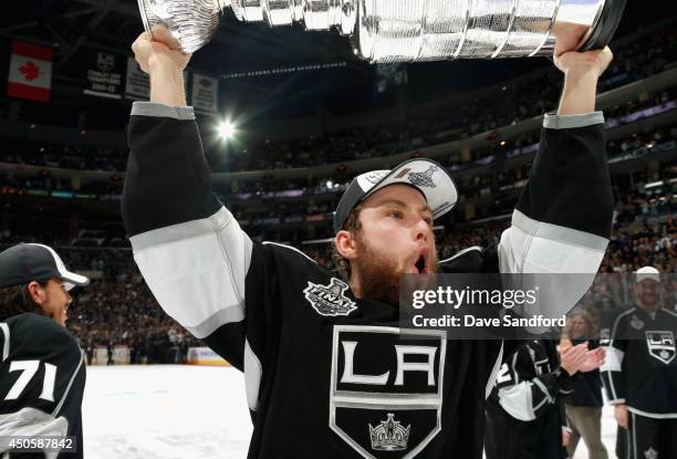 Jake Muzzin of the Los Angeles Kings celebrates as he lifts Stanley Cup after his team won the game 3-2 in double overtime over the New York Rangers...