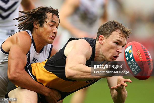 Nathan Foley of the Tigers is tacked by Tendai Mzungu of the Dockers during the round 13 AFL match between the Richmond Tigers and the Fremantle...