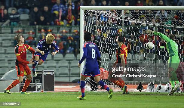 Yoichiro Kakitani of Japan scores the first goal againts Toby Alderweireld of Belgium , Daniel van Buyten and Simon Mignolet of Belgium during the...