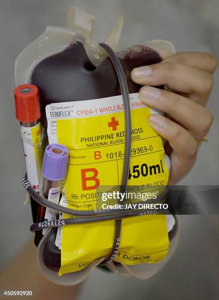 Philippine Red Cross medical staff handles donated blood at a mall in Manila on June 14, 2014 as the world celebrates World Blood Donor Day. The...