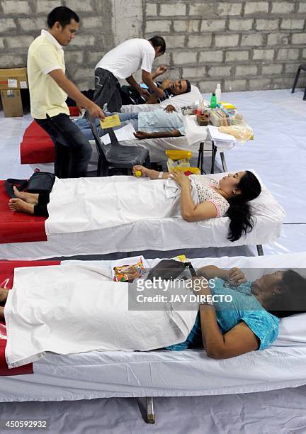 People donate blood to the Philippine Red Cross at a mall in Manila on June 14, 2014 as the world celebrates World Blood Donor Day. The World Health...