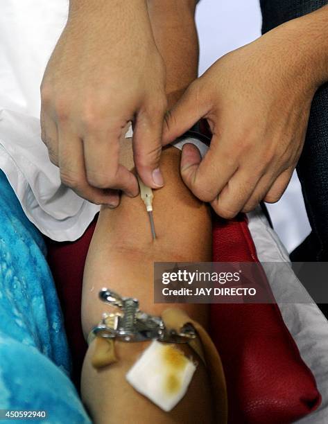 Woman donates blood to the Philippine Red Cross at a mall in Manila on June 14, 2014 as the world celebrates World Blood Donor Day. The World Health...