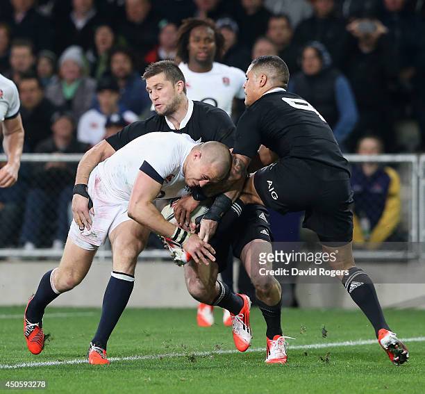 Mike Brown of England scores a try despite being challenged by Cory Jane and Aaron Smith during the International Test Match between the New Zealand...