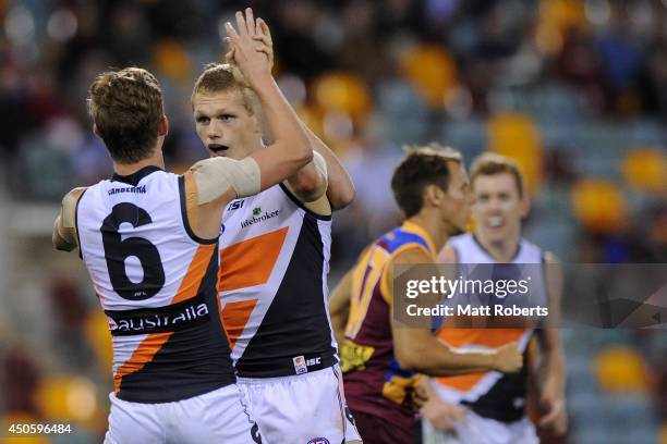 Adam Treloar of the Giants celebrates kicking a goal with Lachie Whitfield during the round 13 AFL match between the Brisbane Lions and the Greater...