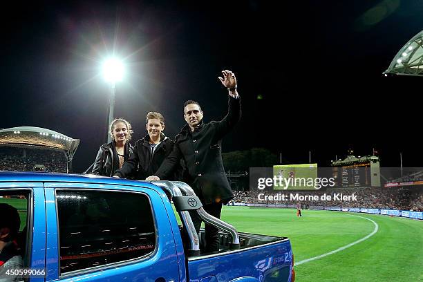 Former Adelaide Crows player Andrew McLeod completes a lap of honour on the back of a ute with his family before the round 13 AFL match between the...