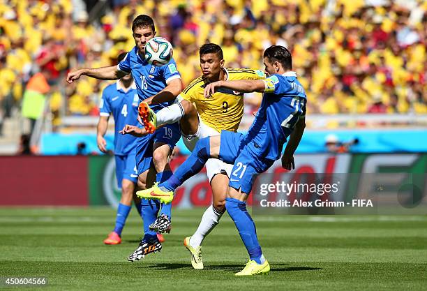 Teofilo Gutierrez of Colombia is challenged by Konstantinos Katsouranis of Greece during the 2014 FIFA World Cup Brazil Group C match between...