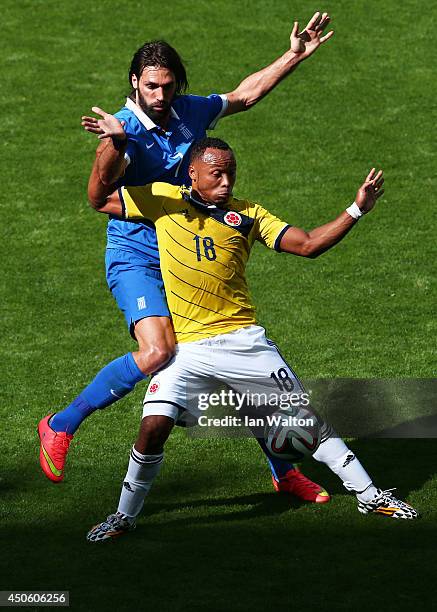 Juan Camilo Zuniga of Colombia holds off a challenge by Giorgos Samaras of Greece during the 2014 FIFA World Cup Brazil Group C match between...