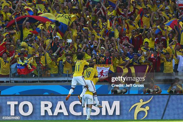 James Rodriguez of Colombia celebrates scoring his team's third goal with Juan Guillermo Cuadrado and Juan Camilo Zuniga during the 2014 FIFA World...