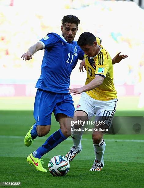 Konstantinos Katsouranis of Greece and James Rodriguez of Colombia battle for the ball during the 2014 FIFA World Cup Brazil Group C match between...