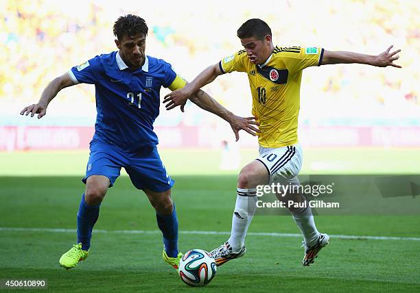 Konstantinos Katsouranis of Greece and James Rodriguez of Colombia battle for the ball during the 2014 FIFA World Cup Brazil Group C match between...