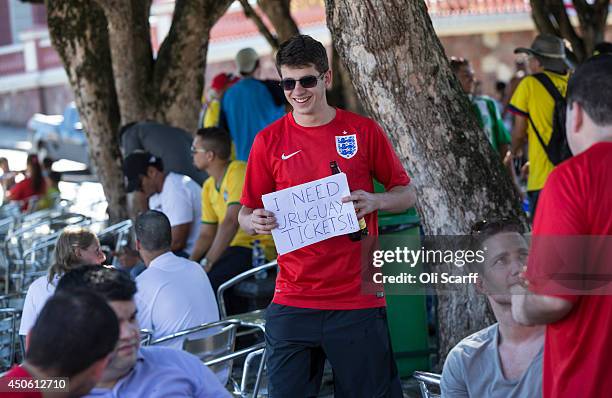 An England football fan walks through Praca Sao Sebastiao with a sign requesting tickets for their next match against Uraguay, ahead of their opening...