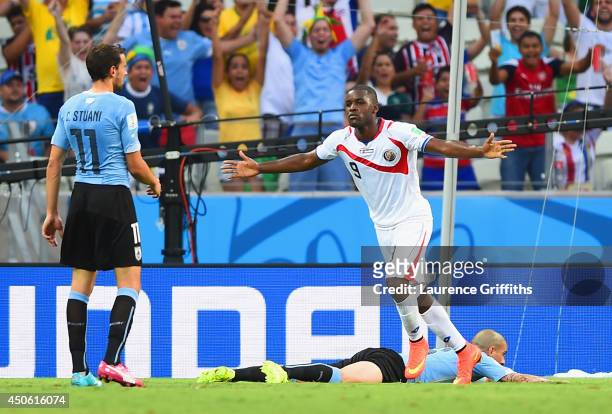 Joel Campbell of Costa Rica celebrates scoring his team's first goal as Christian Stuani of Uruguay looks on during the 2014 FIFA World Cup Brazil...
